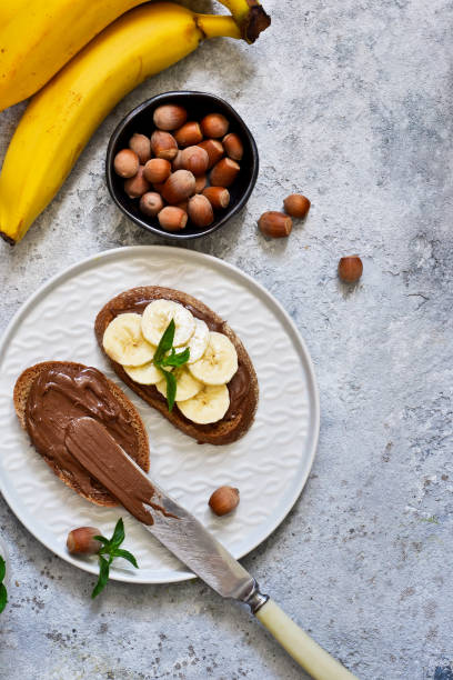 istock Grilled toast with chocolate paste and banana for breakfast on a concrete background. 1009684038