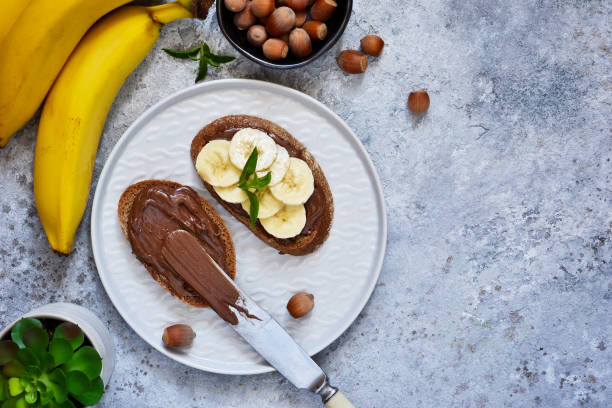istock Grilled toast with chocolate paste and banana for breakfast on a concrete background. 1009684042