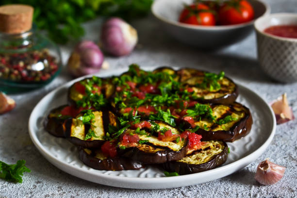 pikante auberginen mit tomaten und koriander. gegrillte auberginen. - eggplant stock-fotos und bilder