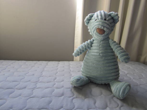istock Blue vintage looking teddy bear on bed 1009696592