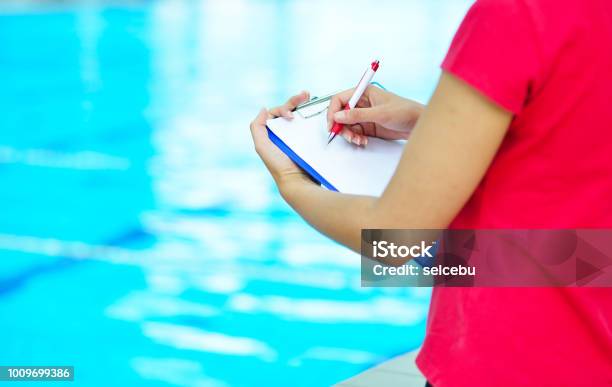 Photo libre de droit de Jolie Formateur En Regardant Le Chronomètre À La Piscine banque d'images et plus d'images libres de droit de Activité physique