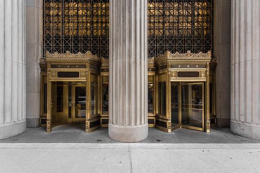 Elaborate golden revolving doors with giant column