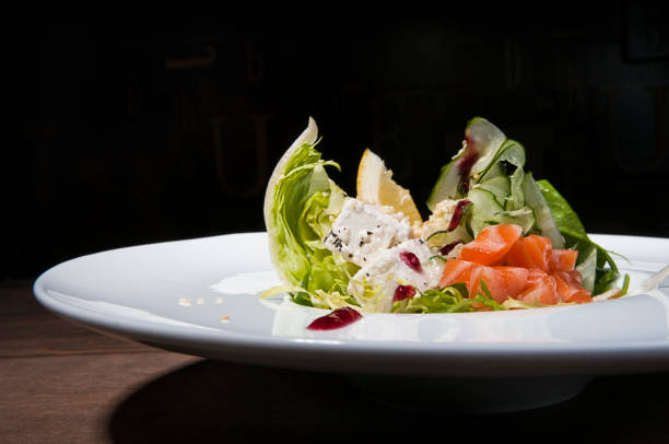 istock Salmon salad with soft cheese on white plat dark background 1009711314