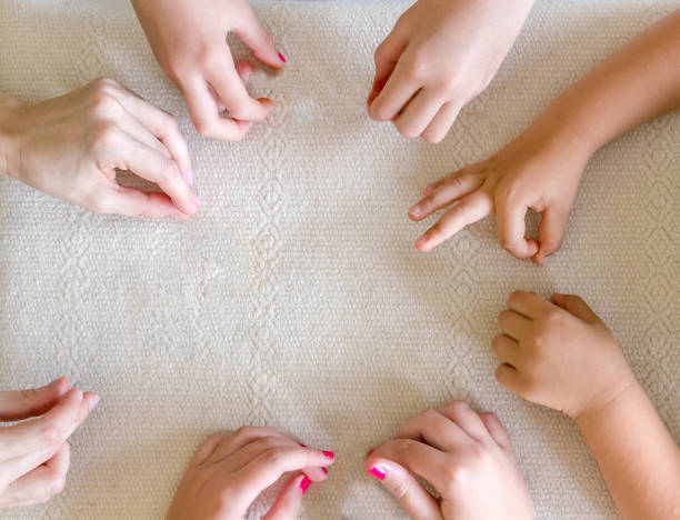 istock Children's and Teacher's hands together on the table. 1009716288