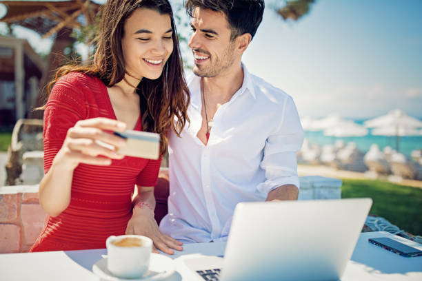 istock Couple is shopping online/making reservation on the beach 1009718394