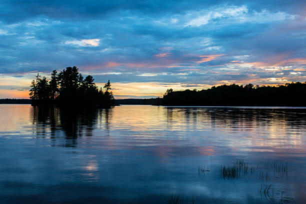 Lake Sunset A beautiful sunset shines through the clouds over a lake in Northern Ontario northern ontario stock pictures, royalty-free photos & images