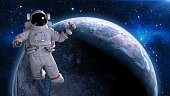 Astronaut in space giving thumbs up, cosmonaut floating above planet Earth, 3D render