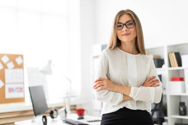 istock A young girl is standing leaning on a table in the office. 1009742096