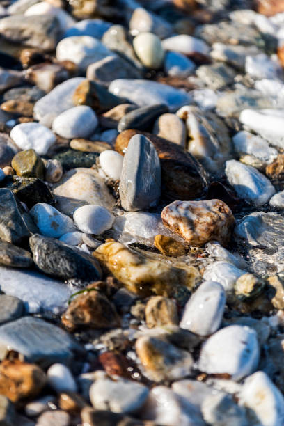 istock Pebble stones and with wave on background in beach, Greece 1009742760
