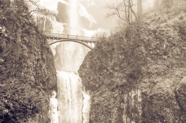 Vintage tone beautiful pedestrian stone bridge and knee-wobbling vantage point over the second tier 69-foot drop of Multnomah Falls lower in winter time. Natural and seasonal waterfall background