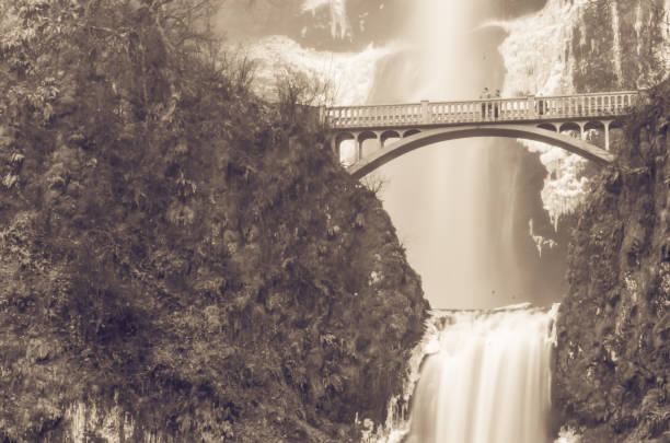 Vintage tone beautiful pedestrian stone bridge and knee-wobbling vantage point over the second tier 69-foot drop of Multnomah Falls lower in winter time. Natural and seasonal waterfall background