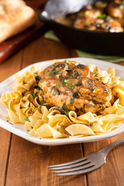Chicken Marsala Chicken Marsala over Pasta/Noodles cooked selective focus vertical pasta stock pictures, royalty-free photos & images