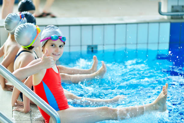 istock Happy children kids group at swimming pool class learning to swim 1009776758