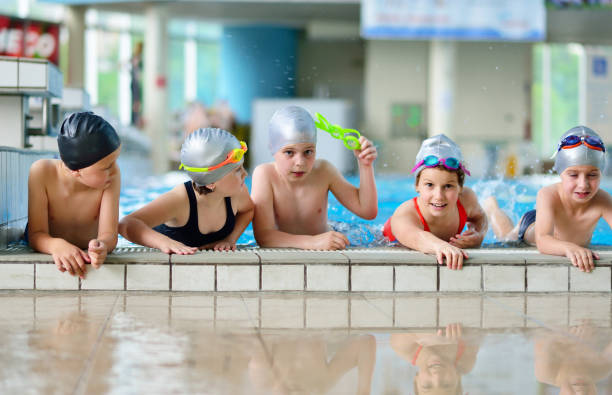 istock Happy children kids group at swimming pool class learning to swim 1009776818