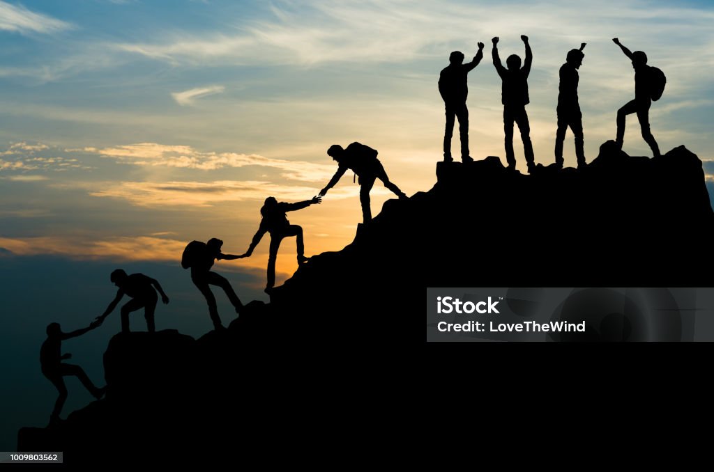 Group of people on peak mountain climbing helping team work , travel trekking success business concept Teamwork Stock Photo
