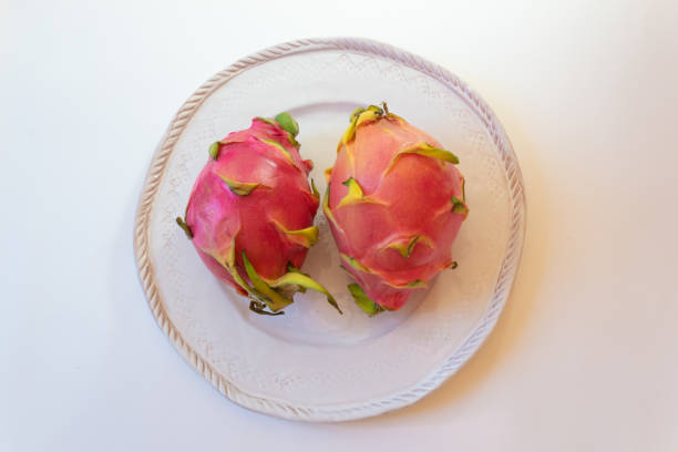 istock Two white dragon fruit on a white plate, Hylocereus undatus, centered 1009803598