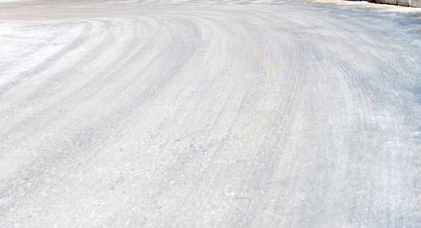 istock Tire tracks in the road covering with snow 1009824802