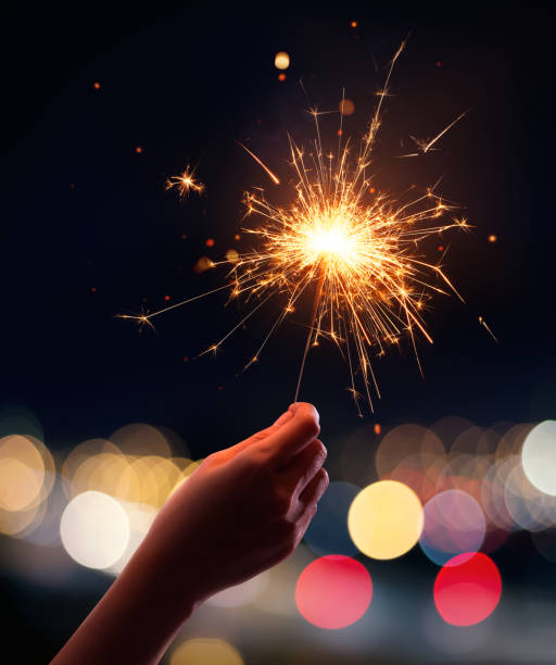 istock Hand holding a sparkler with blurred busy city light 1009830786