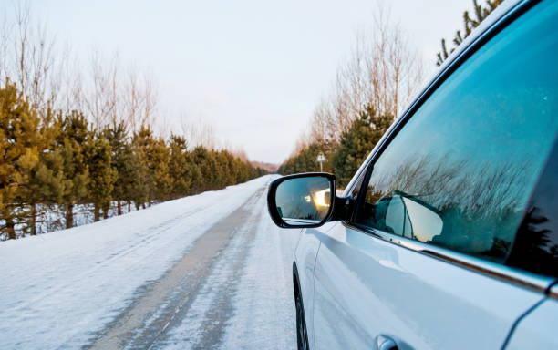 Car driving on country road in winter.