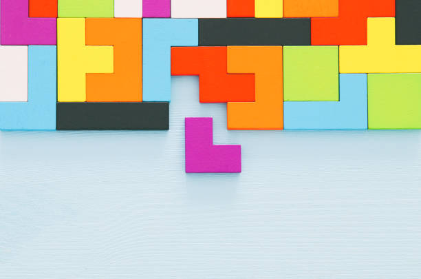 istock A colorful square tangram puzzle, over wooden table. 1009844098