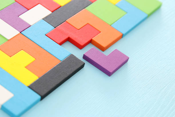 istock A colorful square tangram puzzle, over wooden table. 1009844108
