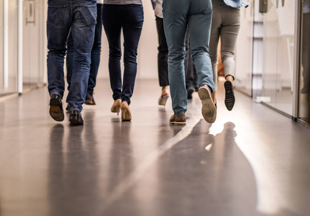 istock Rear view of unrecognizable colleagues running through hallway. 1009861264