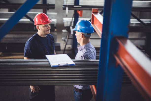 istock Manual worker talking to quality control inspector in aluminum mill. 1009864108