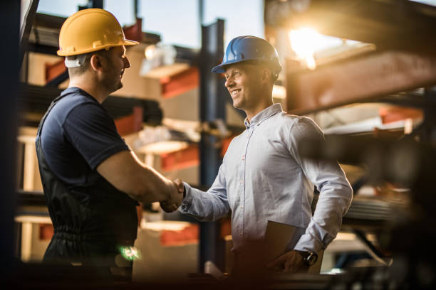 istock Happy manager shaking hands with manual worker in aluminum mill. 1009864622