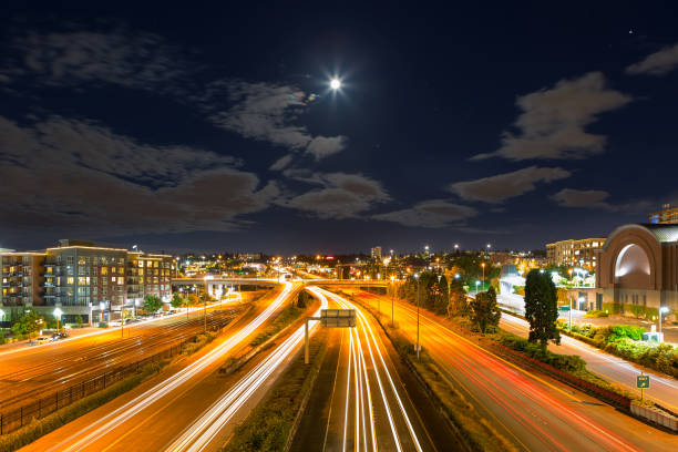 istock Moon Rise over freeway with long exposure light trails in Tacoma WA at night 1009880696