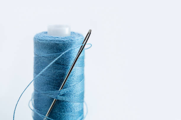 istock In coil of blue thread large needle for sewing. 1009880814