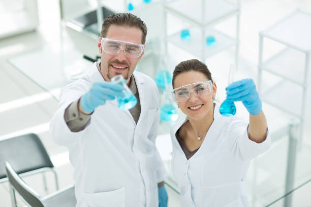 istock happy scientist and assistant show tube with liquid 1009902356