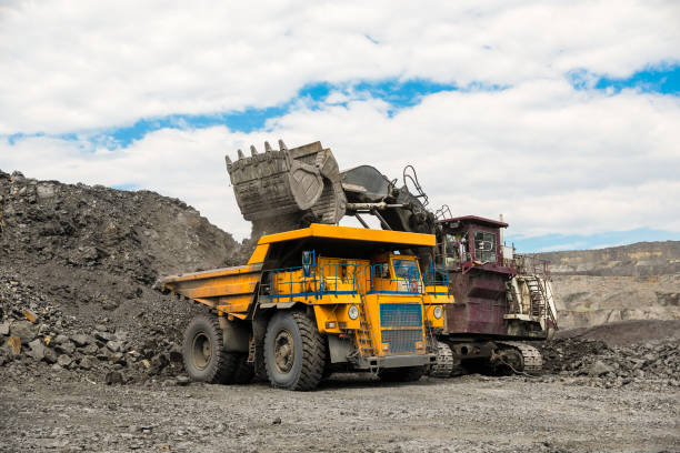 istock Large quarry dump truck. Loading the rock in dumper. Loading coal into body truck. Production useful minerals. Mining truck mining machinery, to transport coal from open-pit as the coal production. 1009906782