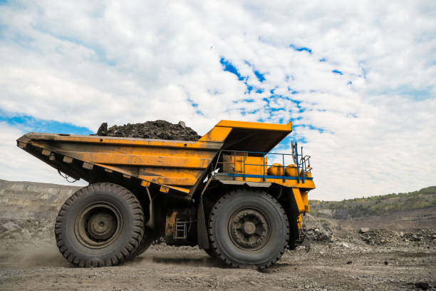 istock Large quarry dump truck. Loading the rock in dumper. Loading coal into body truck. Production useful minerals. Mining truck mining machinery, to transport coal from open-pit as the coal production. 1009906864