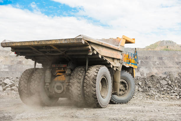 istock Large quarry dump truck. Loading the rock in dumper. Loading coal into body truck. Production useful minerals. Mining truck mining machinery, to transport coal from open-pit as the coal production. 1009906948