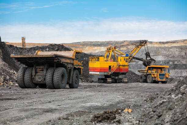 istock Large quarry dump truck. Loading the rock in dumper. Loading coal into body truck. Production useful minerals. Mining truck mining machinery, to transport coal from open-pit as the coal production. 1009907312