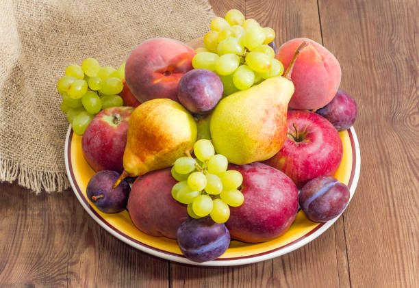 istock Different fruits on the big yellow dish on rustic table 1009914076