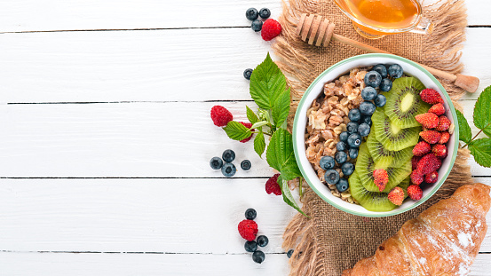 Oatmeal with blueberry strawberries and kiwi. On a wooden background. Top view. Free space for text.