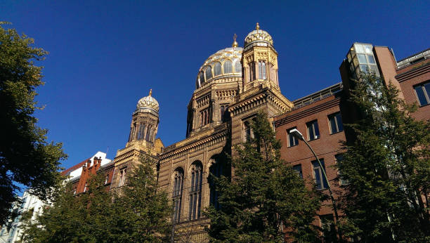 istock Synagogue and green trees in city with blue sky background in Germany 1009917406