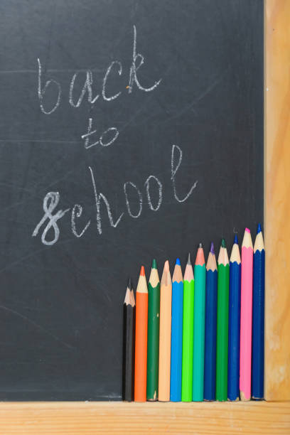 istock Colorful pencils on a black board. School concept 1009925750