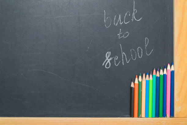 istock Colorful pencils on a black board. School concept 1009925756