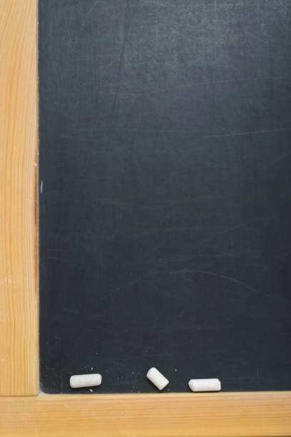 istock Pieces of chalk and paints on black school board 1009925802