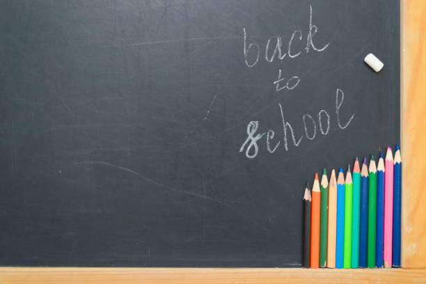 istock Colorful pencils on a black board. School concept 1009925818