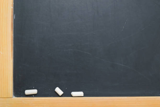 istock Pieces of chalk and paints on black school board 1009925832