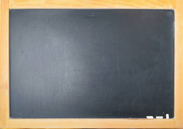 istock Pieces of chalk and paints on black school board 1009925856