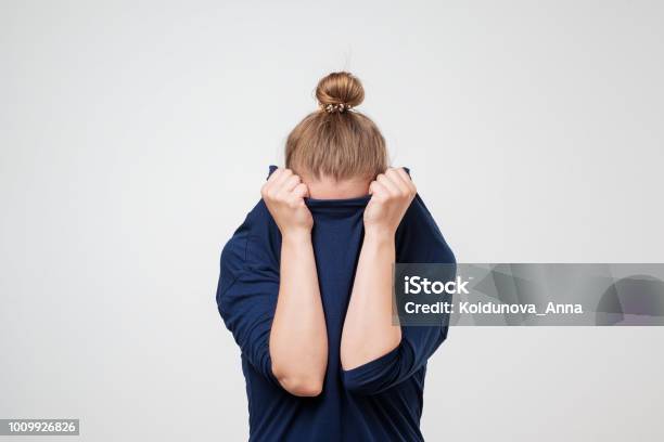 Europäische Frau Gesicht Unter Der Kleidung Versteckt Sie Ist Oulling Pullover Über Den Kopf Stockfoto und mehr Bilder von Verlegenheit