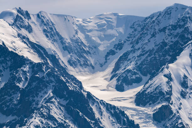 istock Mountain peaks covered with white shiny snow. 1009929482