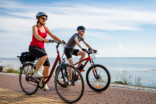 Healthy lifestyle - people riding bicycles at seaside