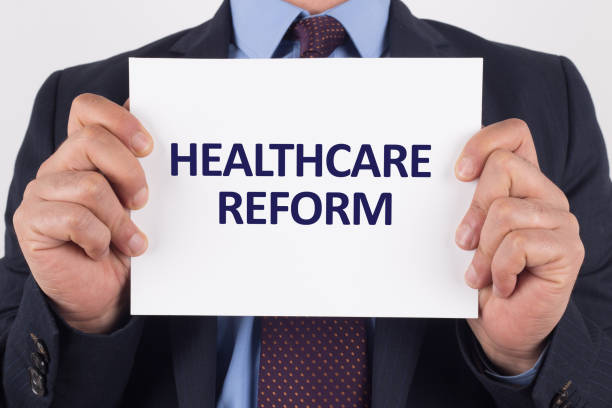istock Man showing paper with HEALTHCARE REFORM text 1009948478