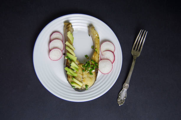 istock Fish steak with avocado and fresh radish served on a white plate 1009952060