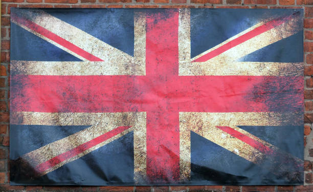 istock an old stained union jack british flag with dark edges on a brick wall background 1009956074